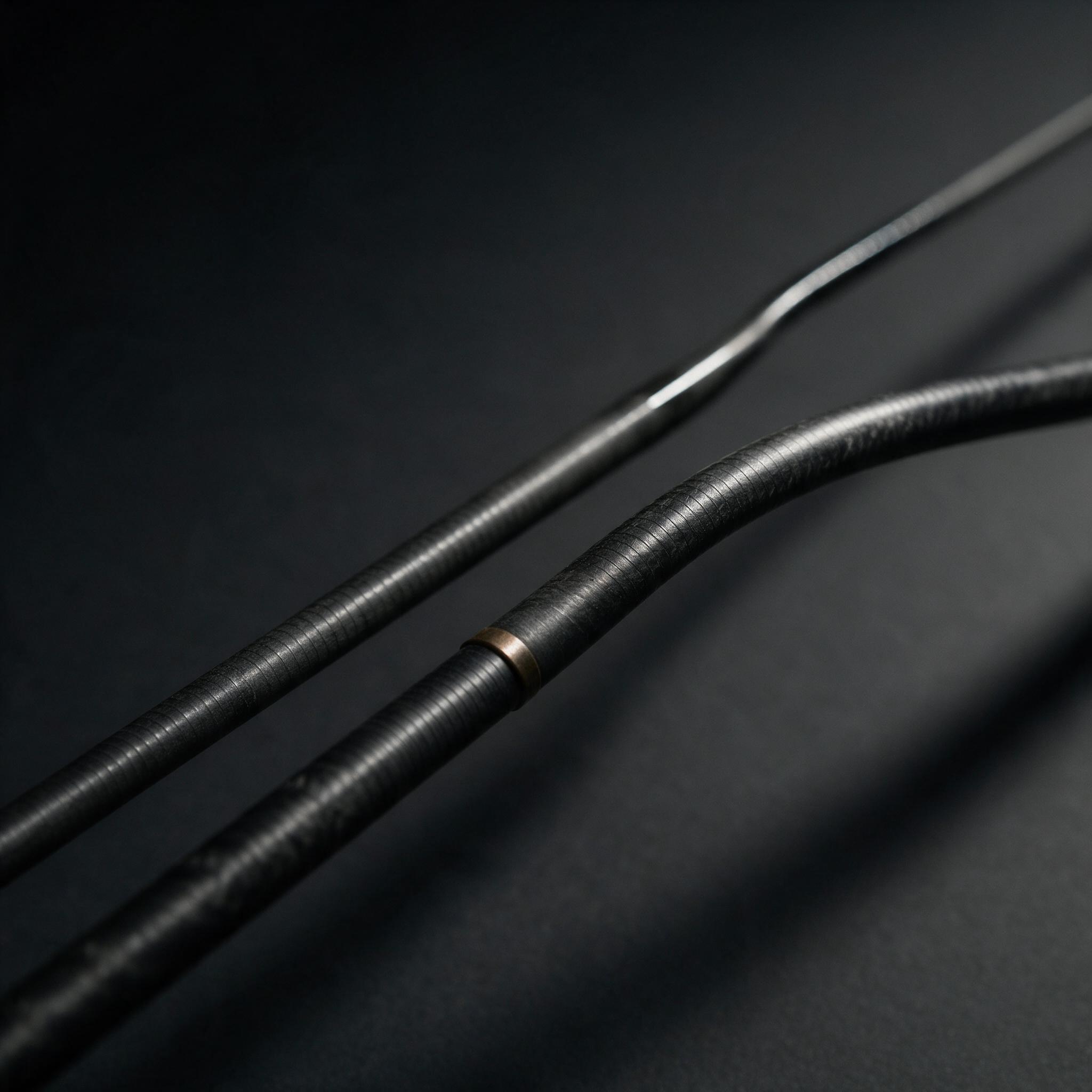 Two carbon rod blanks showing different taper, one arcing smoothly and one holding straight